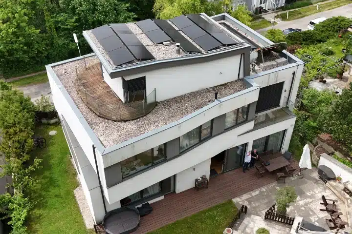 PV-Anlage Flachdach Wien Penzing. Moderne Photovoltaikanlage auf weißem Mehrfamilienhaus