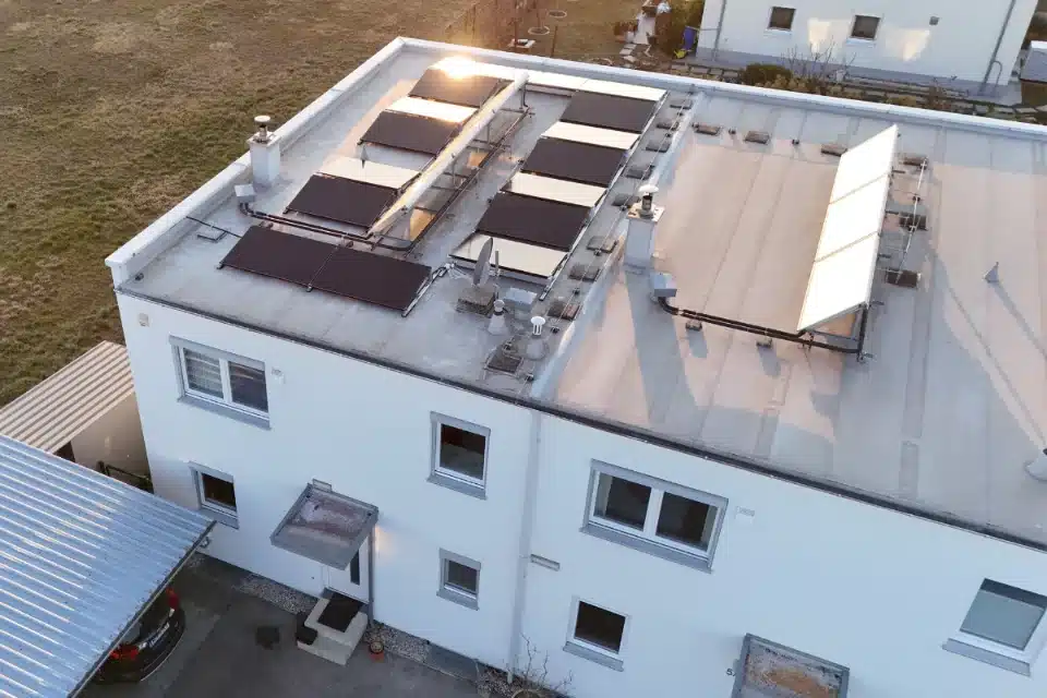PV-Anlage auf Flachdach in Wien Umgebung, Perchtoldsdorf. Moderne Solarmodule auf weißem Wohngebäude.