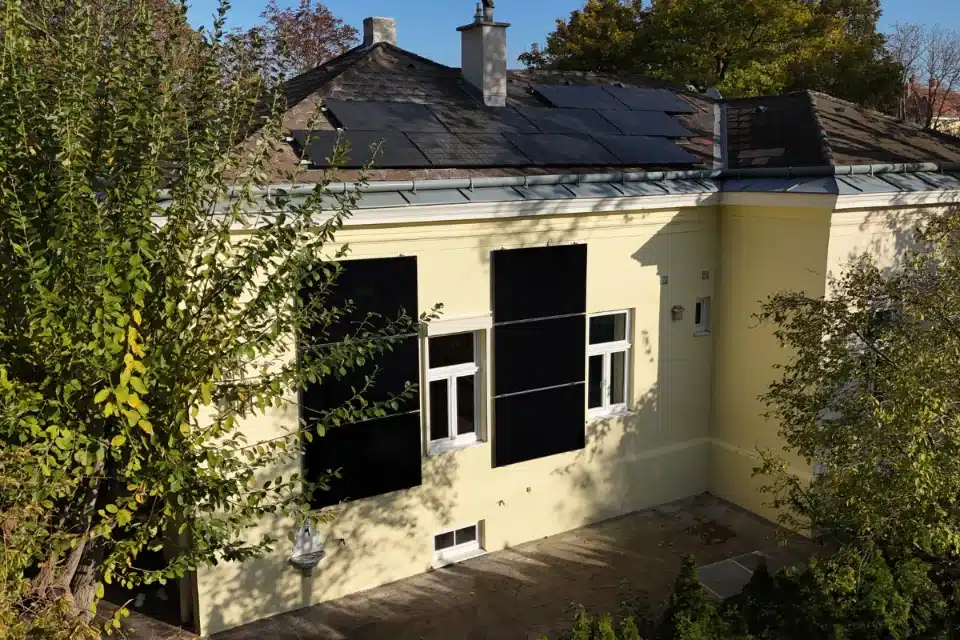 Photovoltaikanlage auf Dach und Fassade eines gelben Hauses in Wien