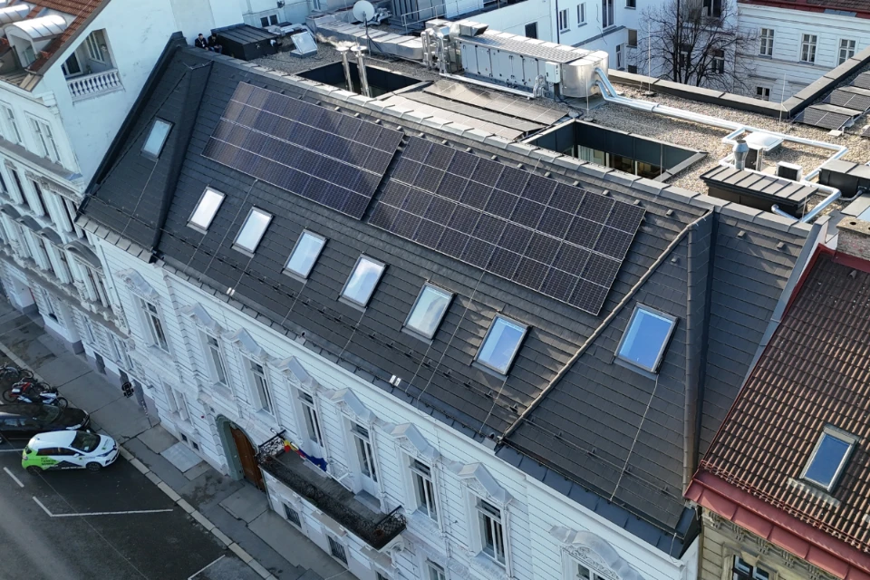 PV Anlage auf der Belgischen Botschaft in Wien von SolarNow Photovoltaik auf einem historischen Gebäude mit dunklem Schrägdach und zahlreichen Dachfenstern, installiert von SolarNow