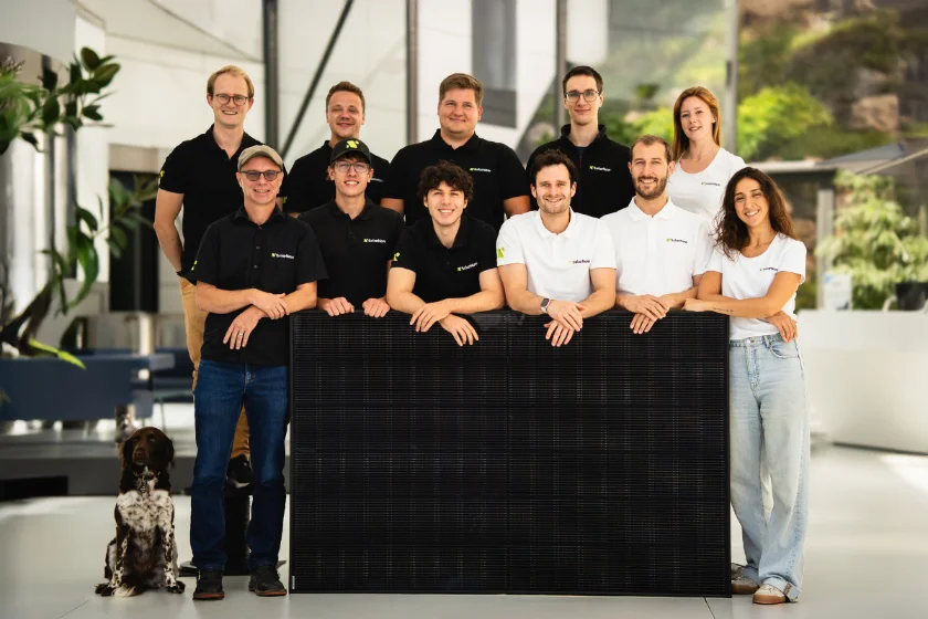 SolarNow Photovoltaik Team Brunn am Gebirge mit Mitarbeiter:innen und Solarmodul im Büro-Foyer